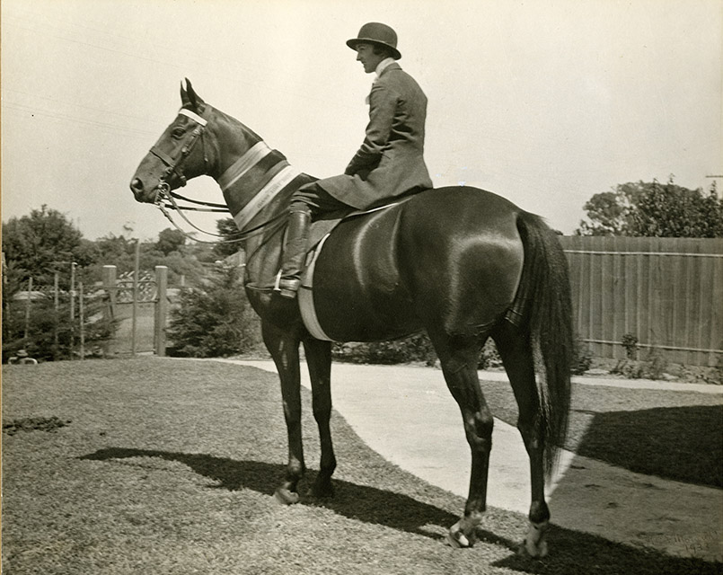 Violet Murrell riding Garryowen with competition ribbons, c. 1934.